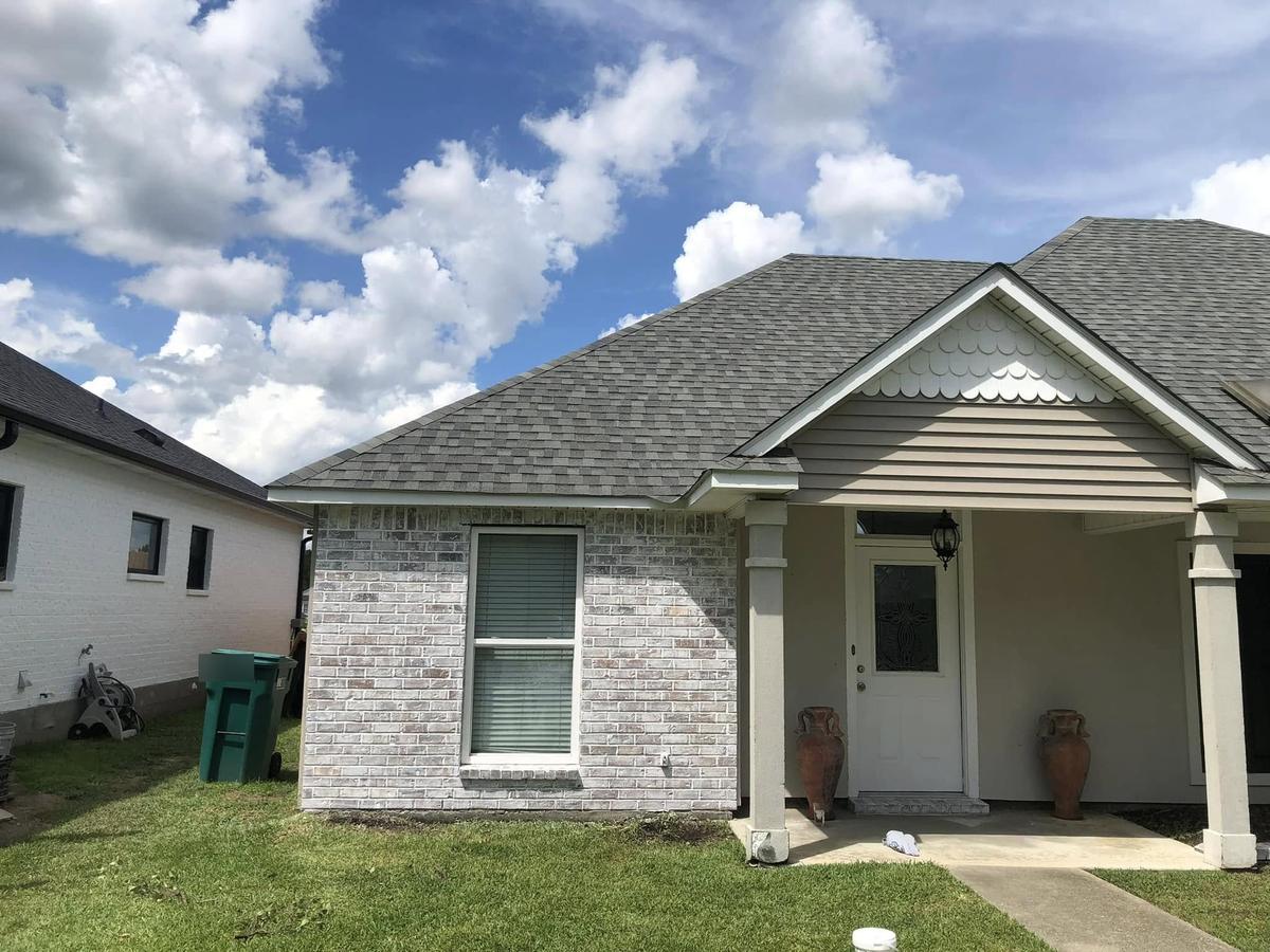 After: the same house with the brick whitewashed, the porch columns cream and the door white
