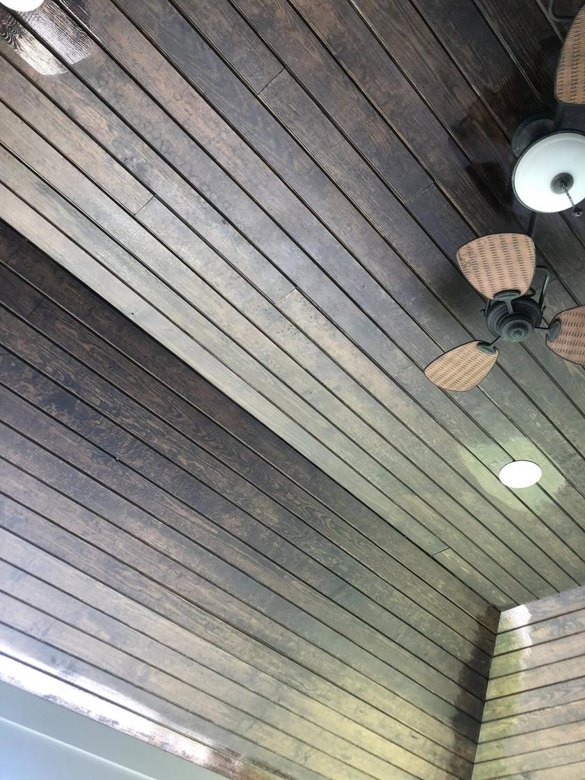 Before: a covered patio ceiling with faded, blotchy boards