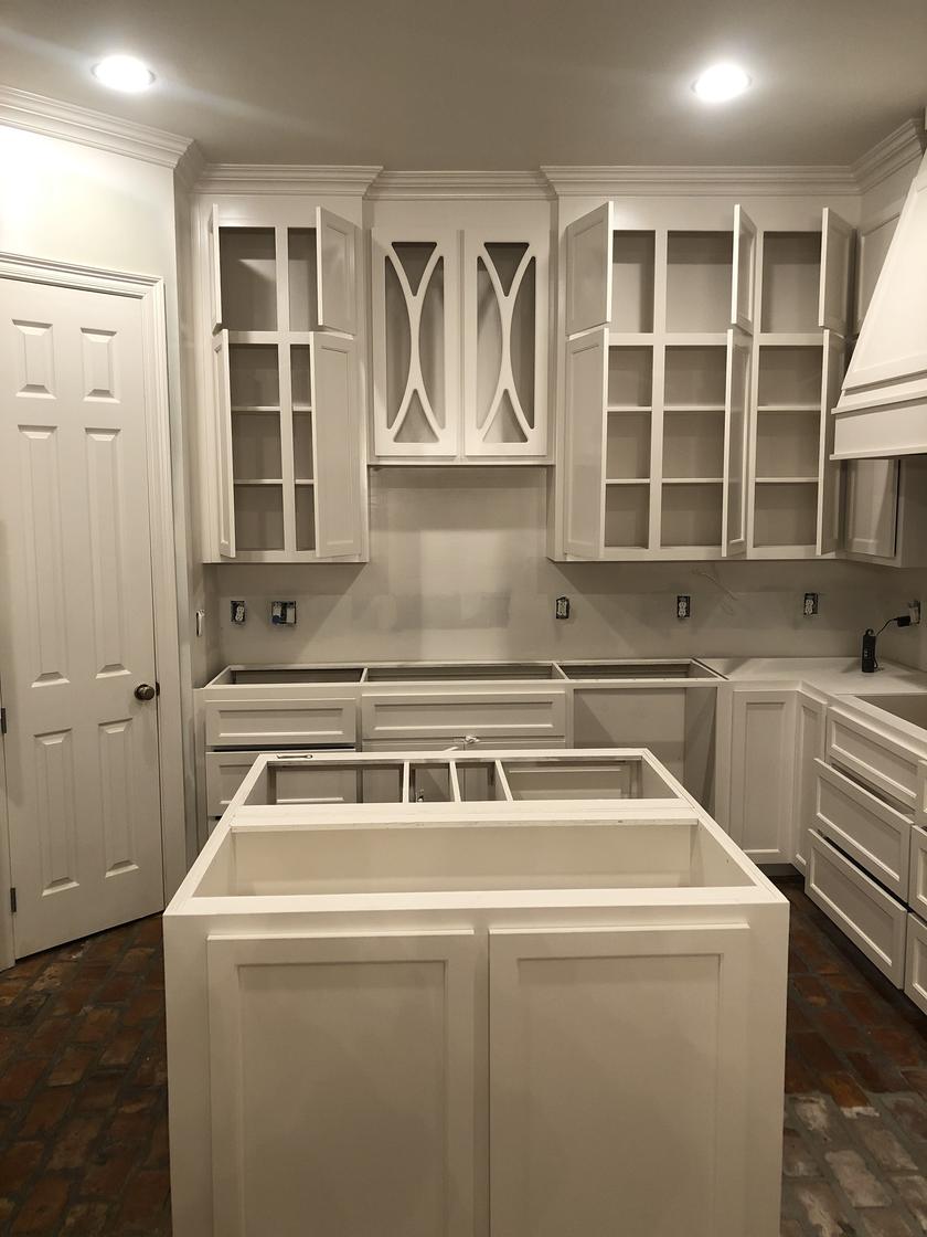 After: the same cabinets and island sprayed white, before the countertops