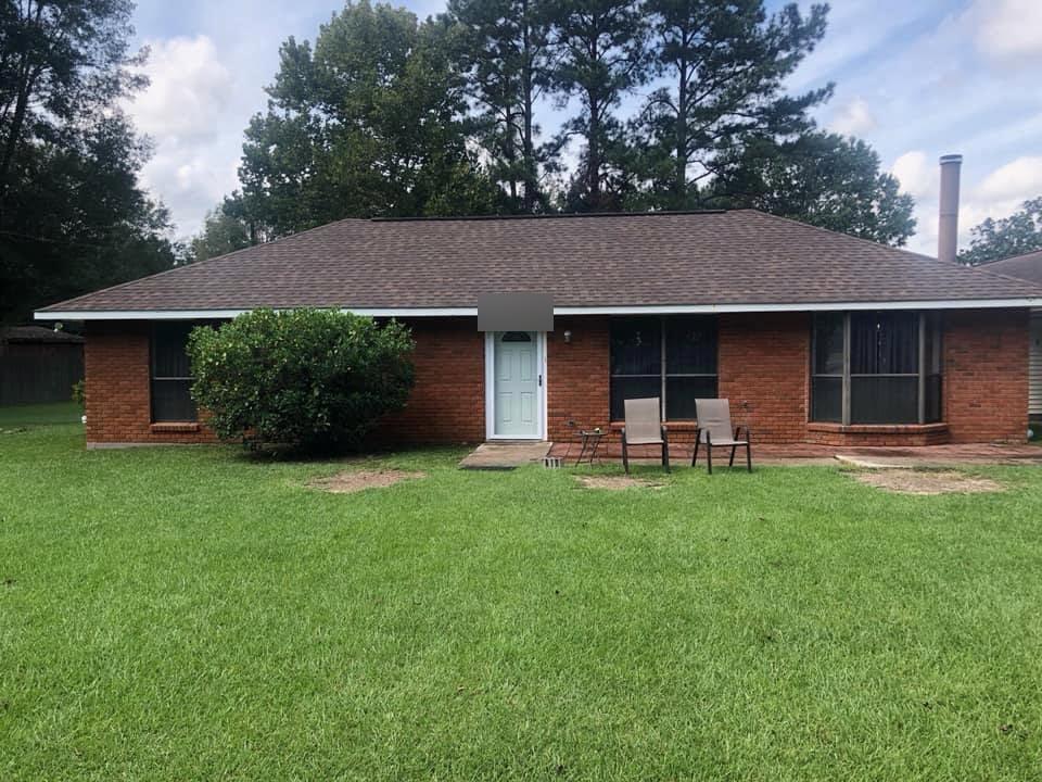 Before: the front of a brick ranch in its original orange-red brick