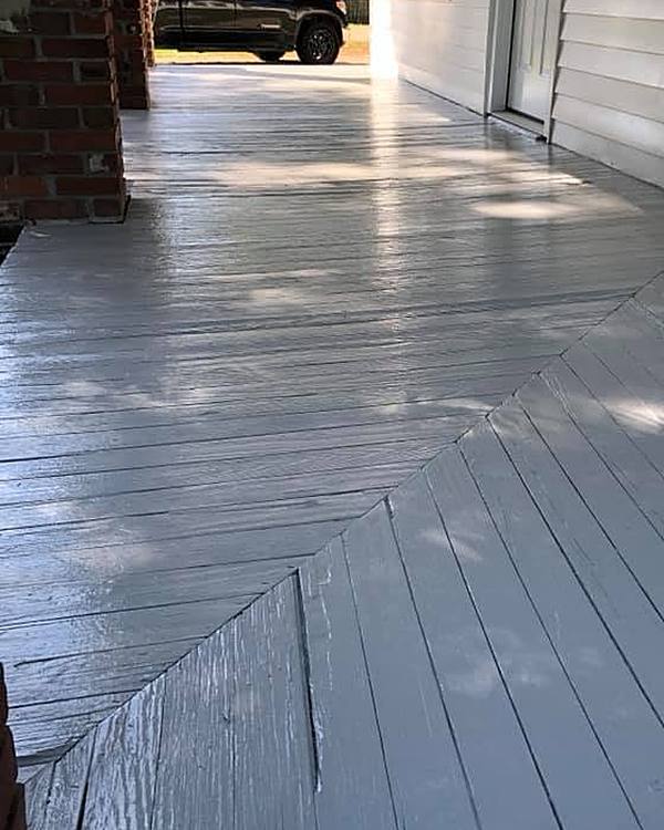 A wraparound porch floor painted light grey