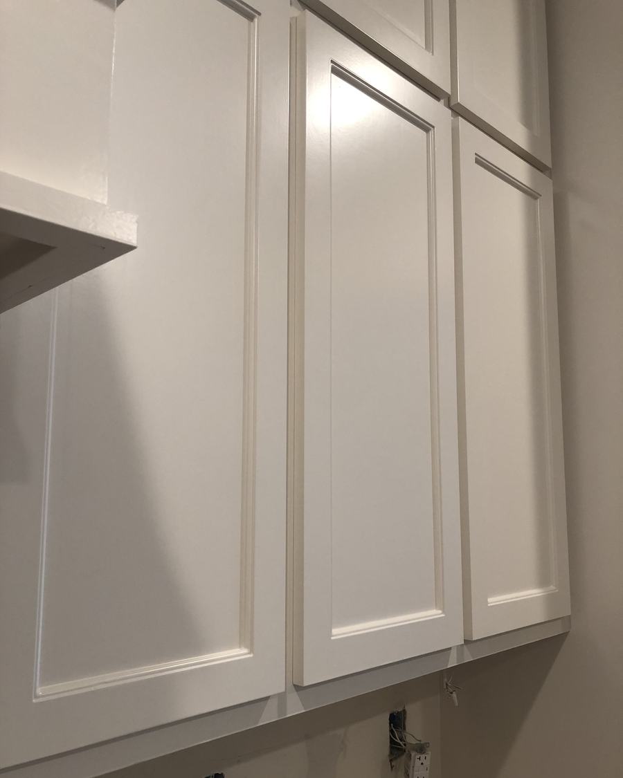 Shaker cabinet doors in raking light, showing a smooth white finish