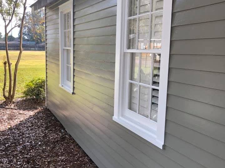 Lap siding painted sage green with crisp white window casings