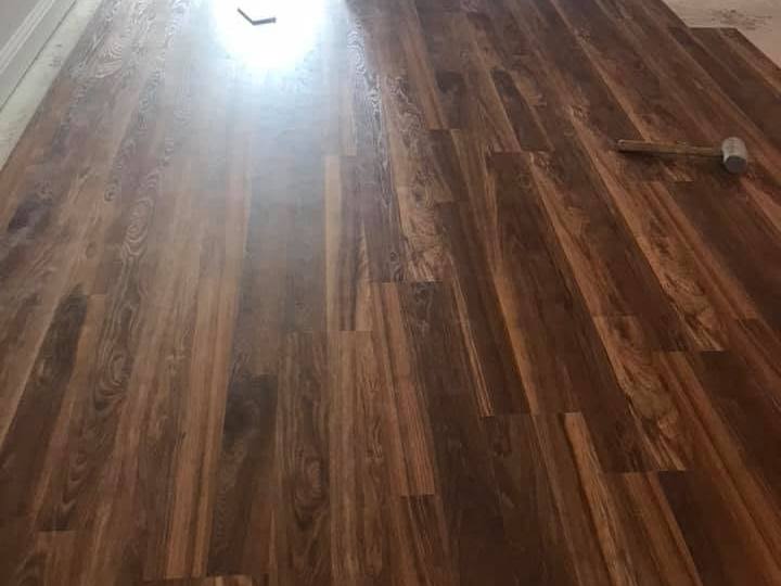 New wood-look plank flooring laid through a room into a hall