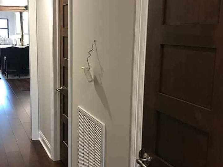 A hallway in light grey with white trim and dark stained doors