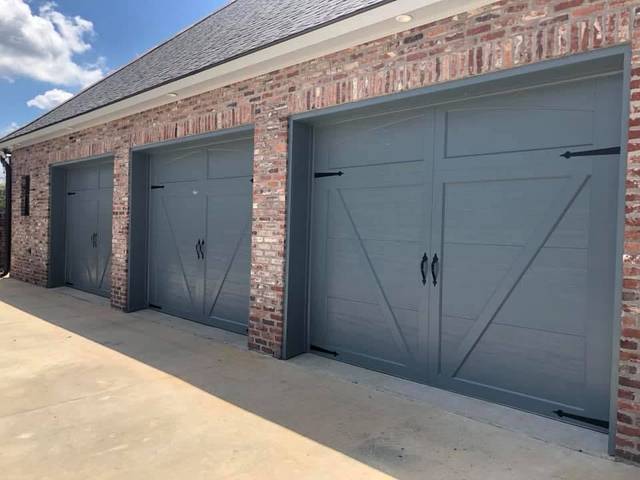 Three carriage-style garage doors painted slate grey on red brick