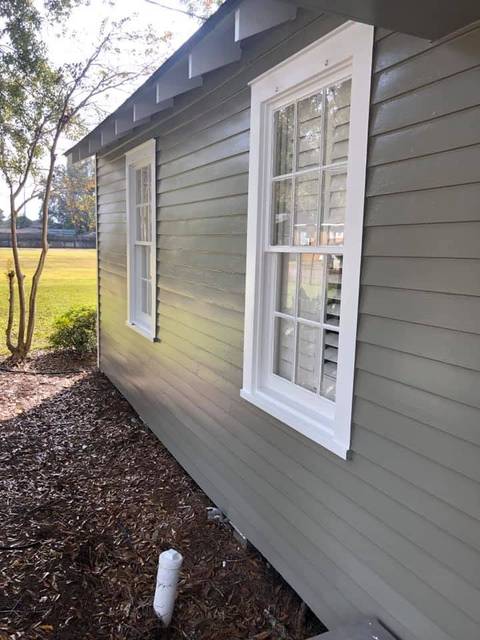 Lap siding painted sage green with white casings
