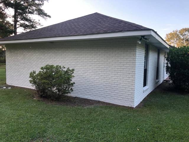 The side and back of a white-painted brick ranch
