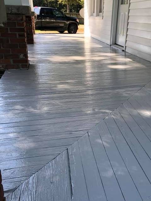 A wraparound porch floor painted light grey