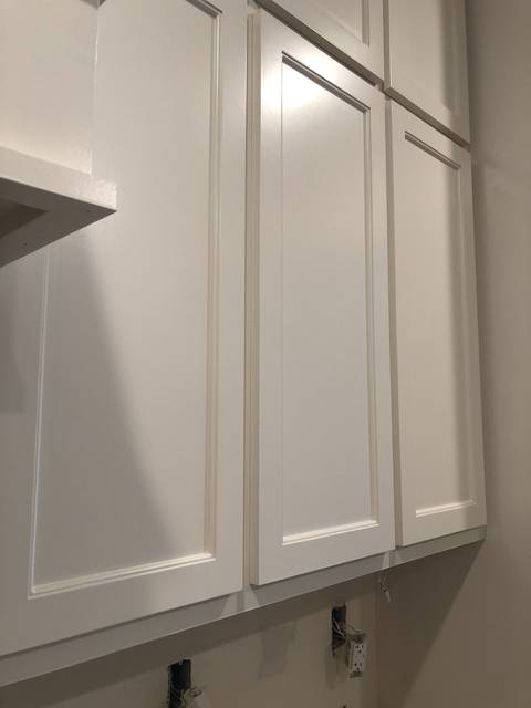 Shaker cabinet doors in raking light, showing a smooth white finish