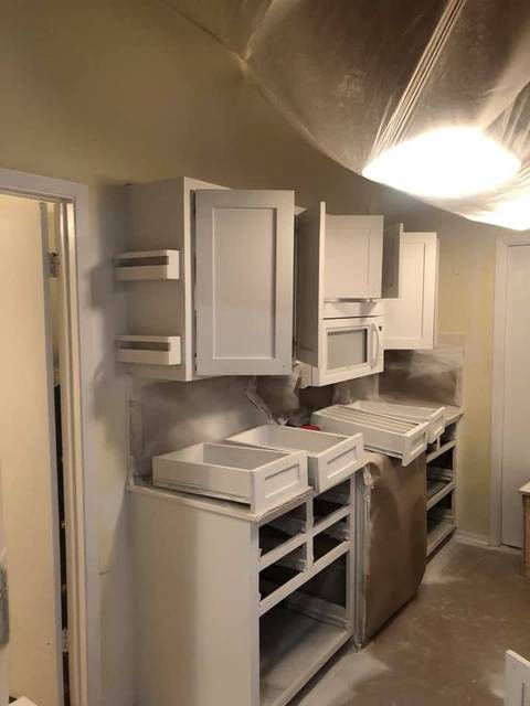 Cabinet doors sprayed white, the room masked in plastic