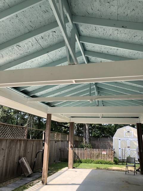 A covered patio ceiling painted a light seafoam green