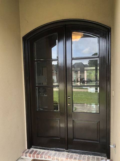 Arched double front doors stained dark walnut